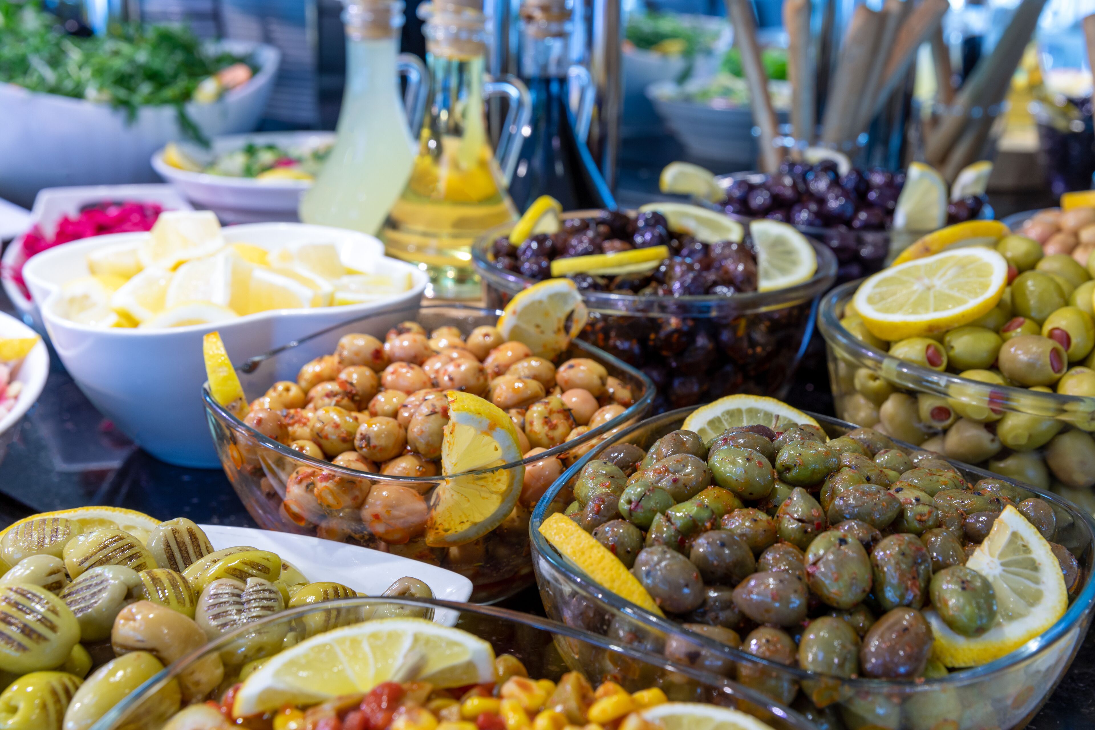 A buffet with various food items including olives, lemons, and other fruits.