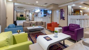 A modern hotel lobby with a reception desk, seating areas, and a bar. - Dies Hotel (Diyarbakir)