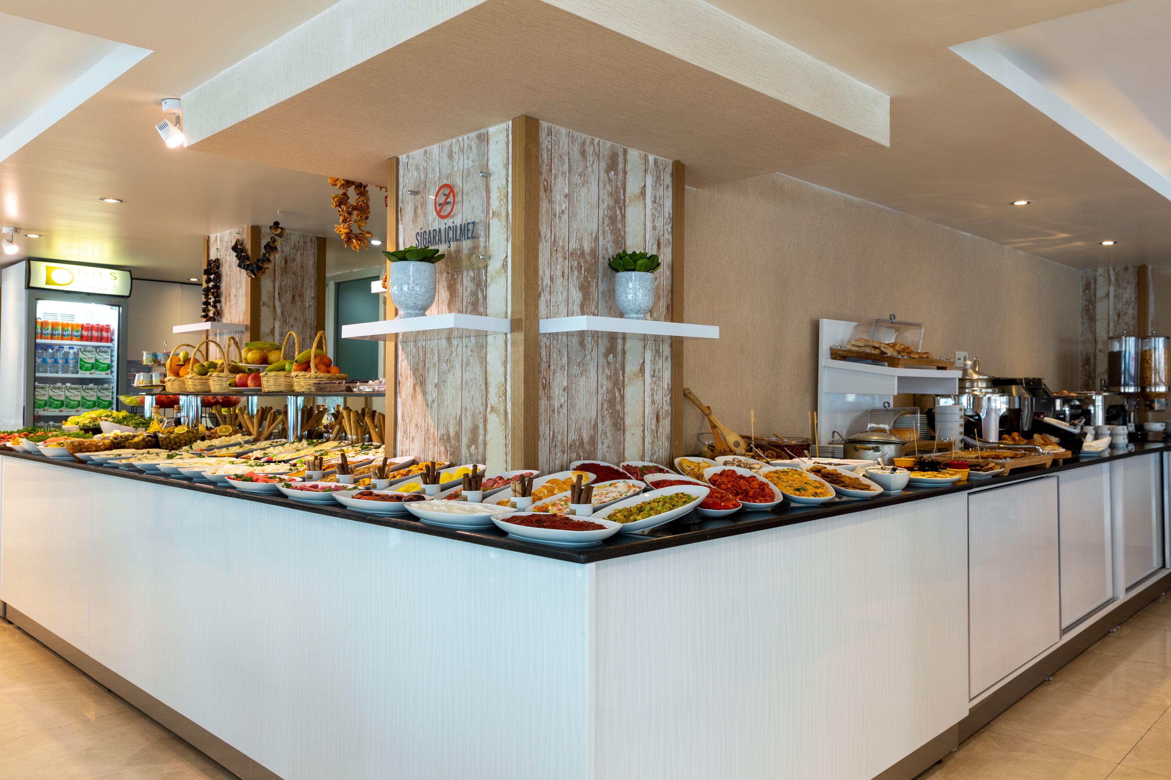 Un buffet proposant une variété de plats et un réfrigérateur rempli de boissons.