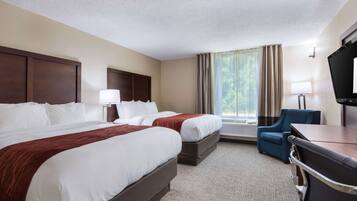 A hotel room with two beds, a desk, a chair, a TV, and a window with curtains.