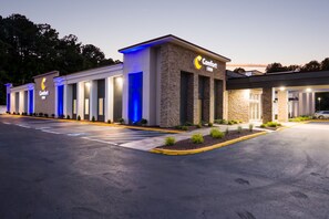 A Comfort Inn hotel with a modern facade, well-lit entrance, and a parking lot.