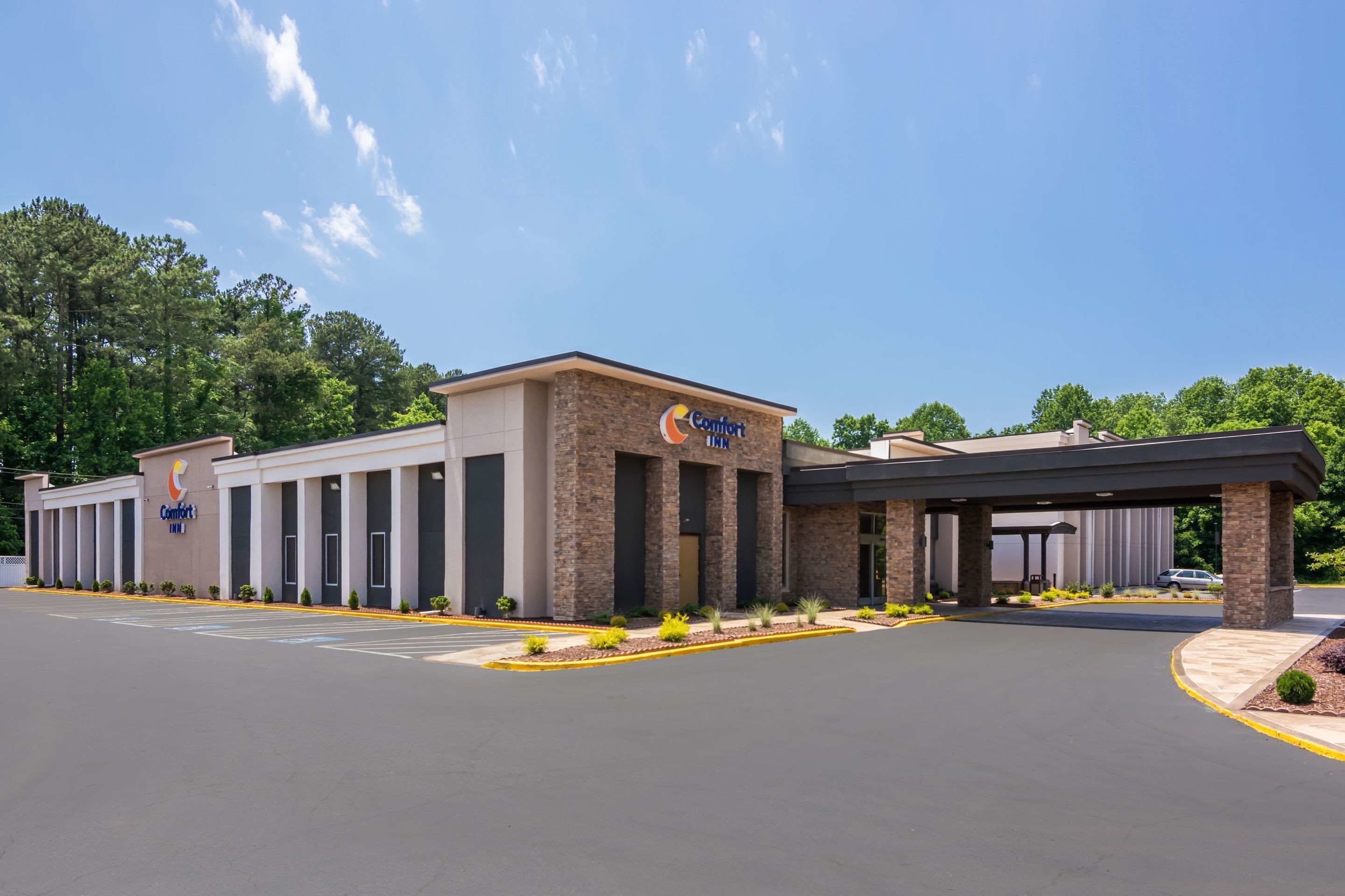 A Comfort Inn hotel with a modern design, featuring a central entrance and multiple rooms visible in the background.