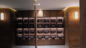 A room with wooden shelving units containing multiple bowls and a central light fixture.