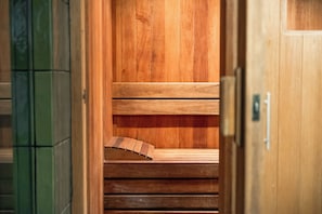 A wooden sauna with benches and a door. - Maria Condesa (Mexico City)