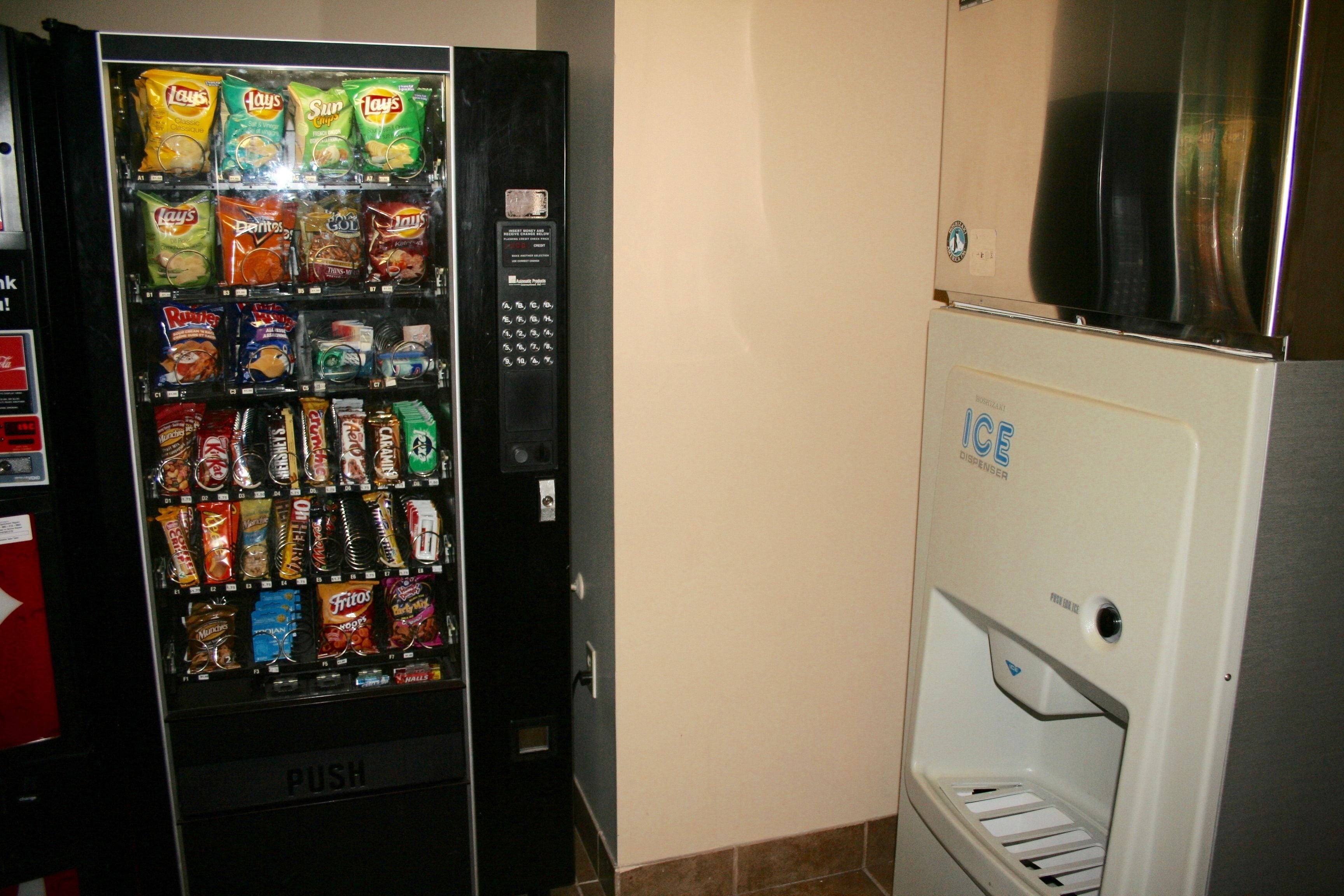 A vending machine with snacks and a push button for dispensing items.