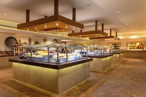 A buffet area with multiple food stations, a patterned floor, and a ceiling with wooden beams and recessed lighting. - Fort Arabesque Resort, Spa & Villas (Makadi Bay)