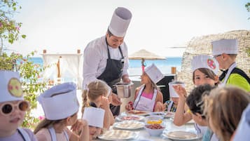 A group of people dining outdoors with a chef serving food.