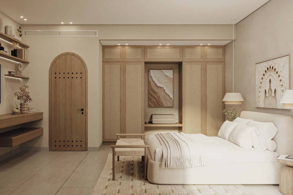 A modern bedroom with a large bed, built-in shelving, a TV, and a wardrobe.