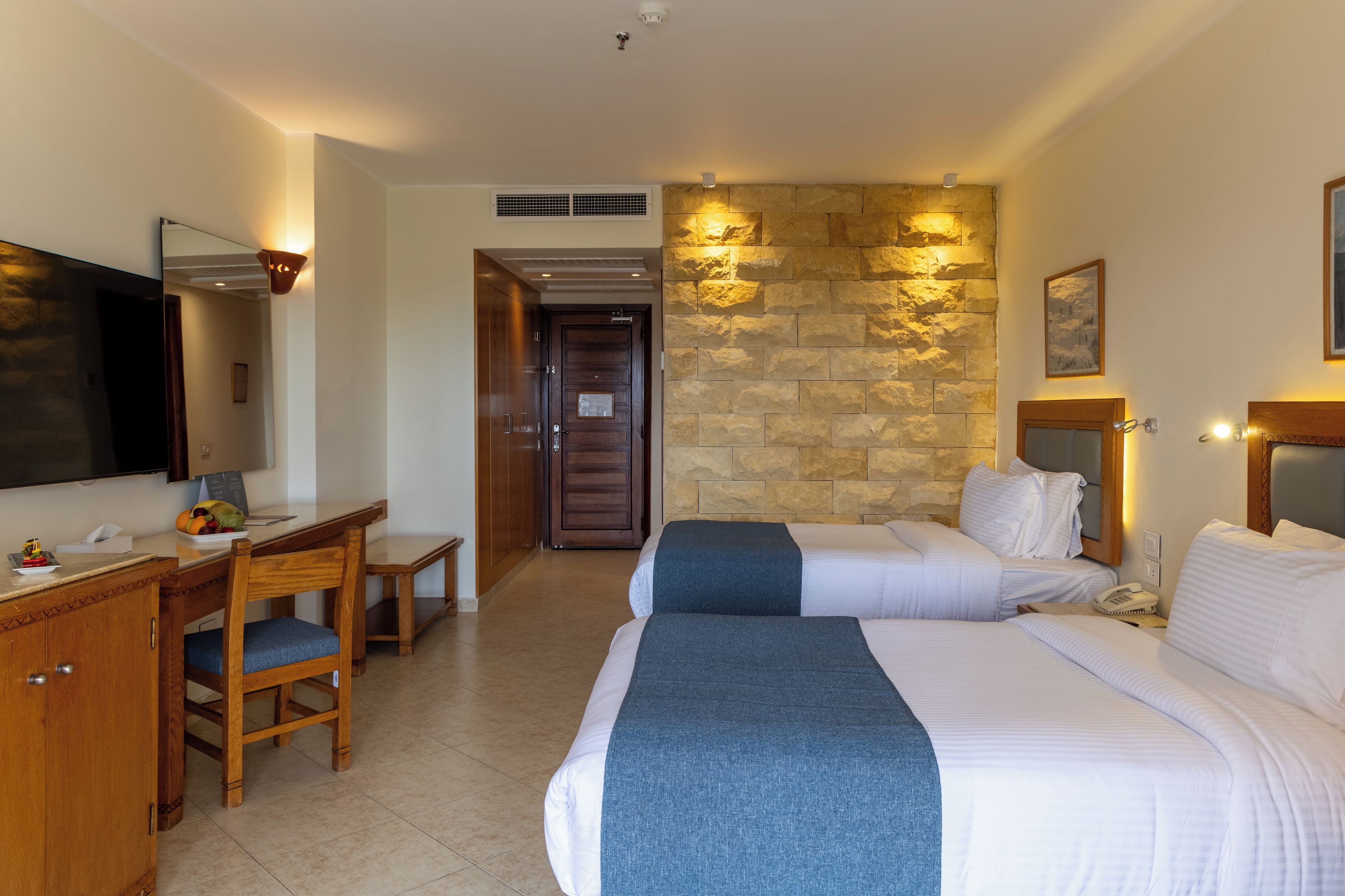 Une chambre d’hôtel équipée d’un lit, d’un bureau, d’une chaise et d’un téléviseur.