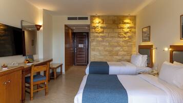 Une chambre d’hôtel équipée d’un lit, d’un bureau, d’une chaise et d’un téléviseur.