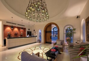 A hotel lobby with a reception desk, seating area, and a decorative chandelier. - Fort Arabesque Resort, Spa & Villas (Makadi Bay)