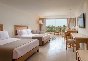 A hotel room with two beds, a desk, a chair, and a balcony with a view. - Fort Arabesque Resort, Spa & Villas (Makadi Bay)