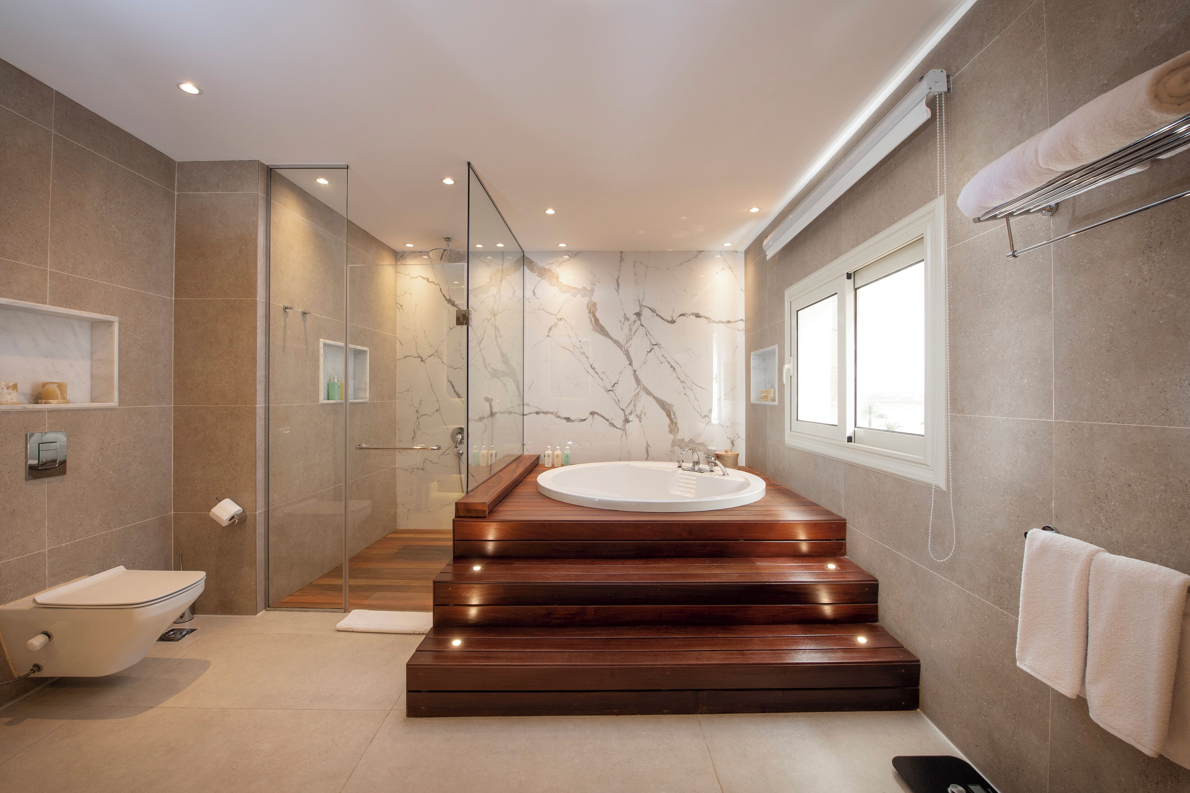 Une salle de bain moderne avec une baignoire sur pieds, une douche à parois de verre et un meuble-lavabo avec un miroir.
