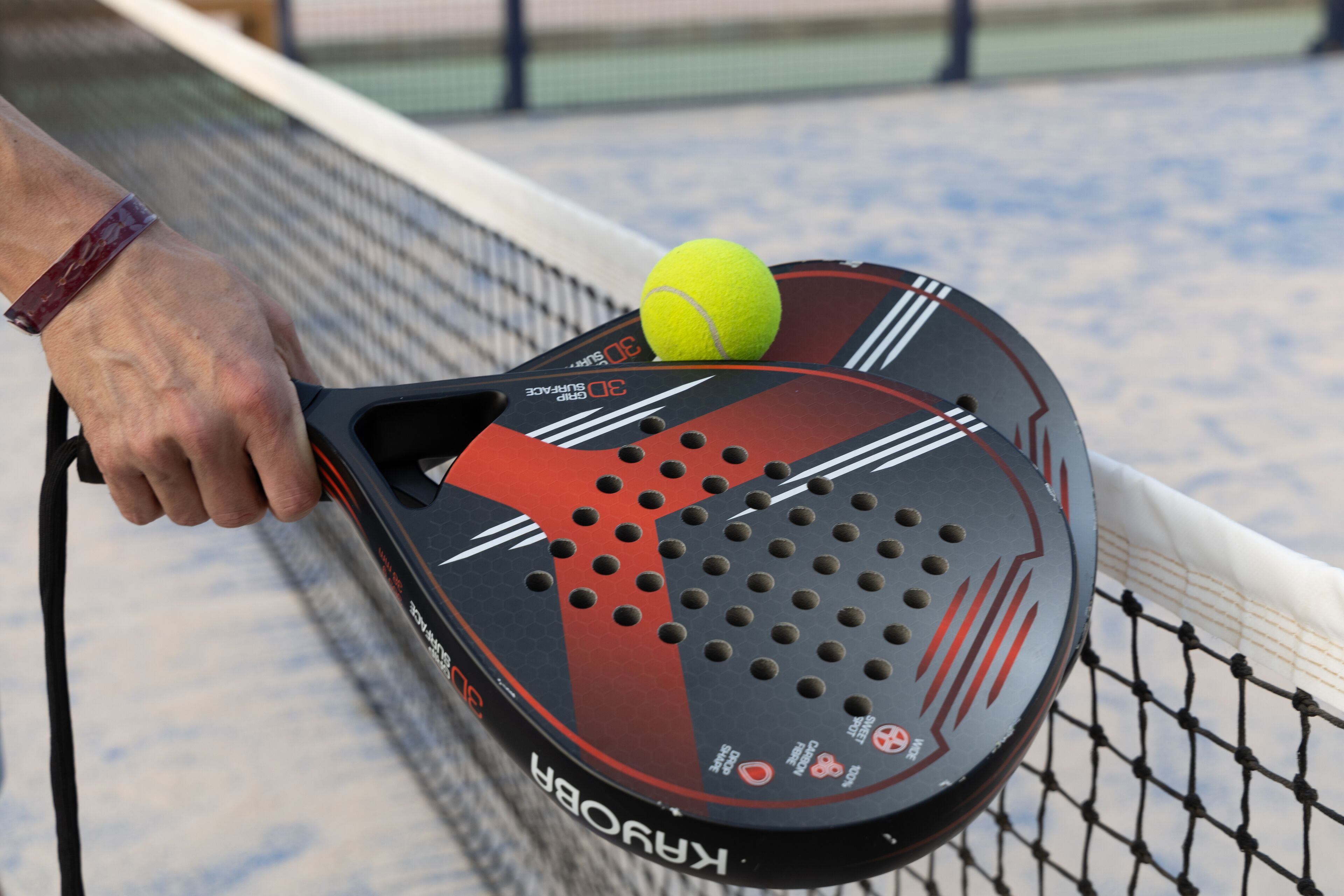 Una raqueta de tenis con una pelota amarilla.