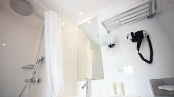 A modern bathroom with a shower, a hairdryer, and a mirror.
