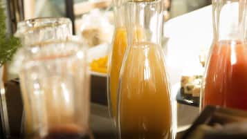 A close-up of three glass bottles with different colored liquids, likely juices or smoothies, on a tray.