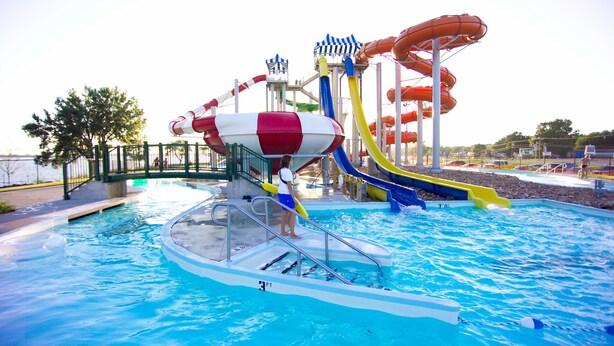 A water park with a pool, slides, and a lifeguard stand. - King's Pointe Waterpark Resort (Storm Lake)