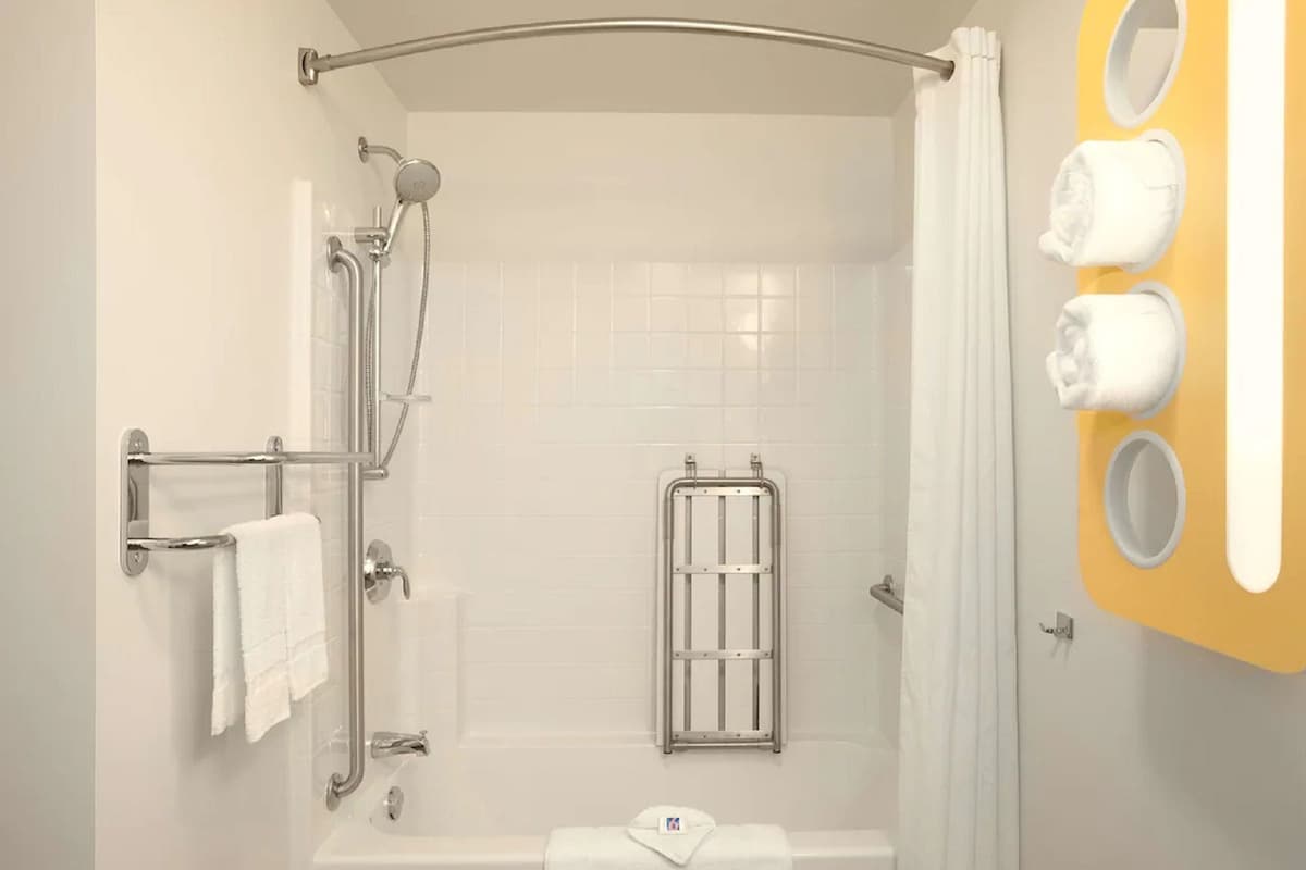 A modern bathroom with a shower, toilet, and a towel rack.