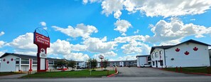 A Canadian motel with a prominent sign, multiple buildings, and a clear sky.