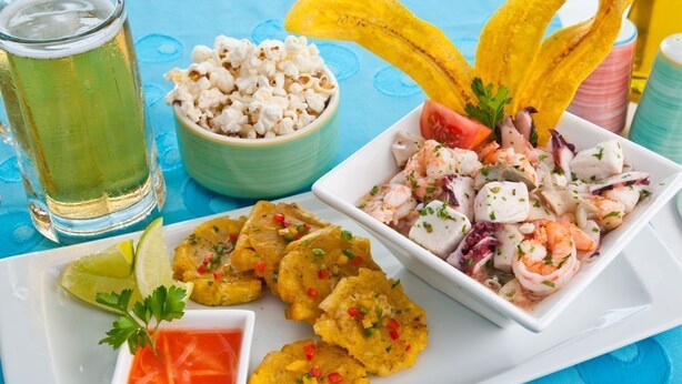 A plate with shrimp salad, fried plantains, and popcorn.