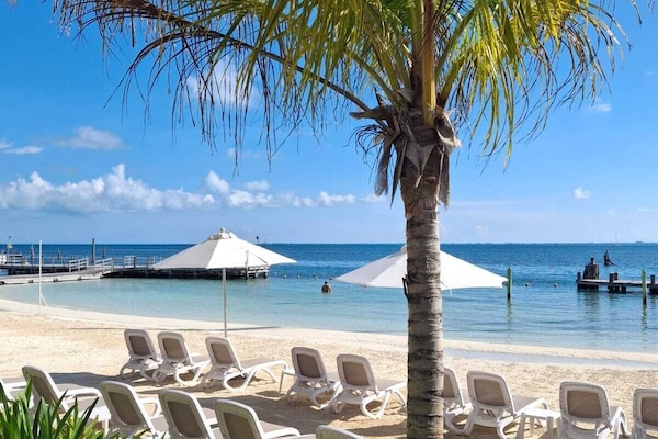 En la playa, playa de arena blanca, camastros y sombrillas