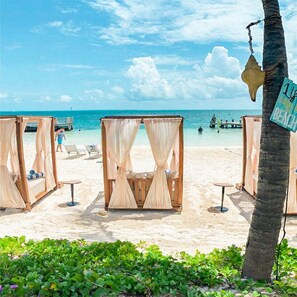 On the beach, white sand, sun loungers, beach umbrellas