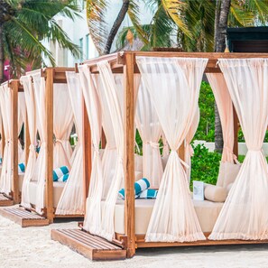 On the beach, white sand, sun loungers, beach umbrellas