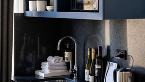 Una cocina moderna con una estantería para vinos, un lavamanos y una tetera.
