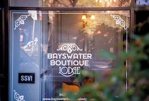 Une devanture de magasin avec l’inscription « BAYSWATER BOUTIQUE LODGE » et un numéro de téléphone.