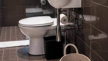 A modern bathroom with a toilet, a sink, and a shower area.