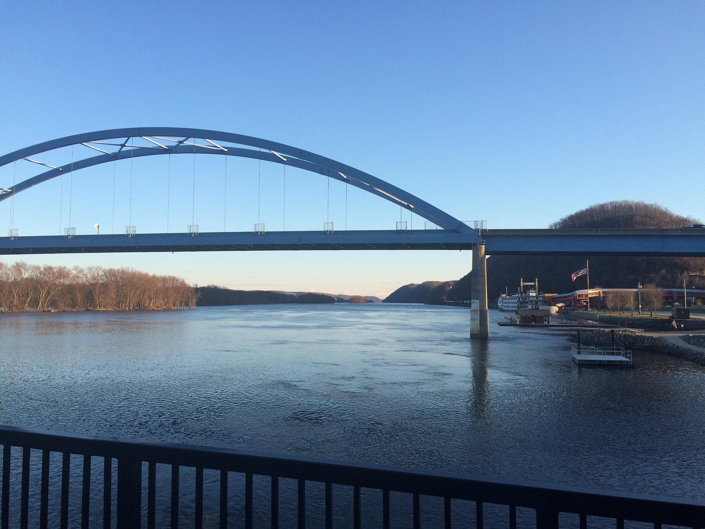 A large bridge spanning a river with a clear sky.