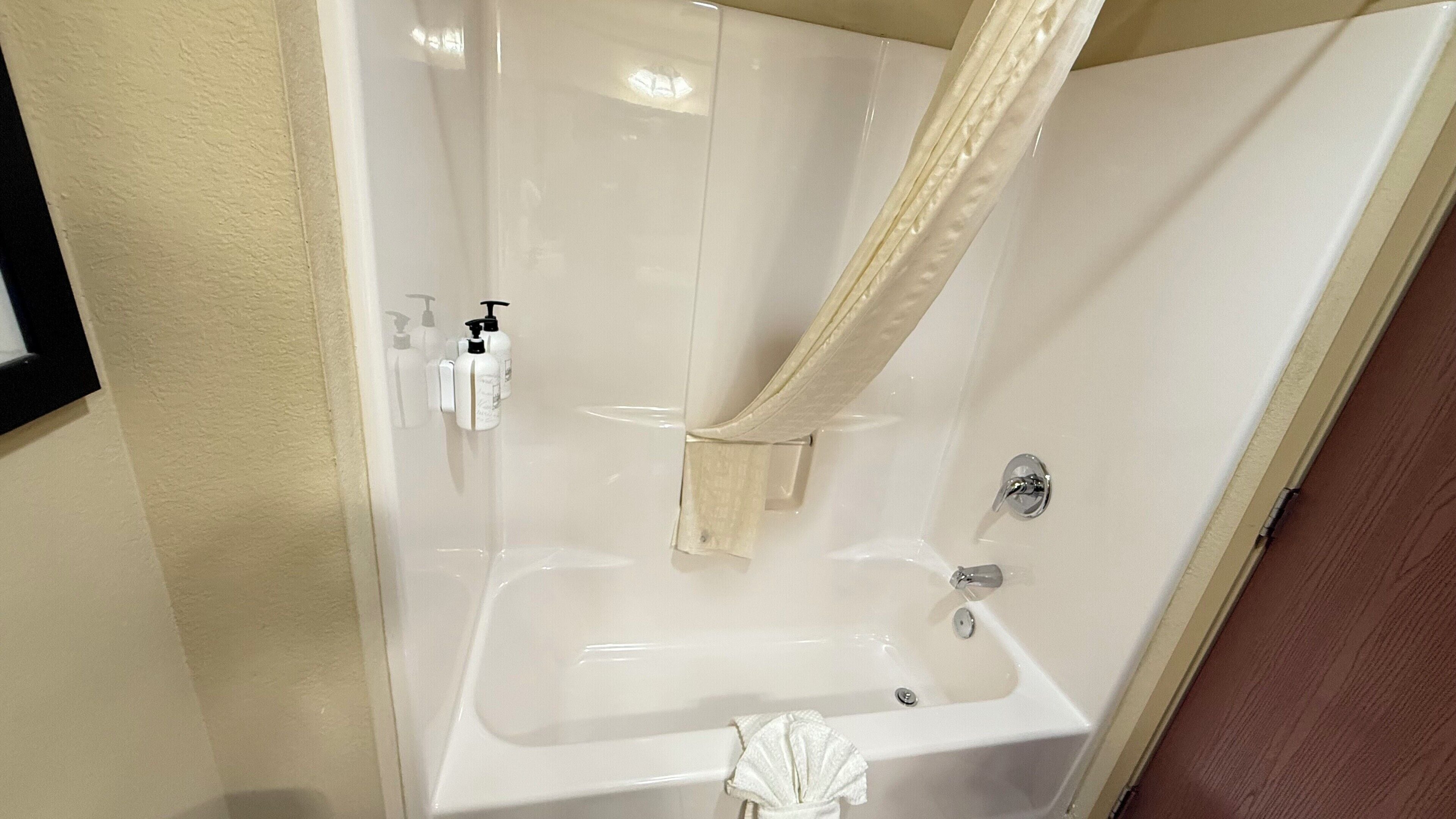 Une salle de bain moderne avec une douche à parois de verre, une baignoire blanche et des toilettes.