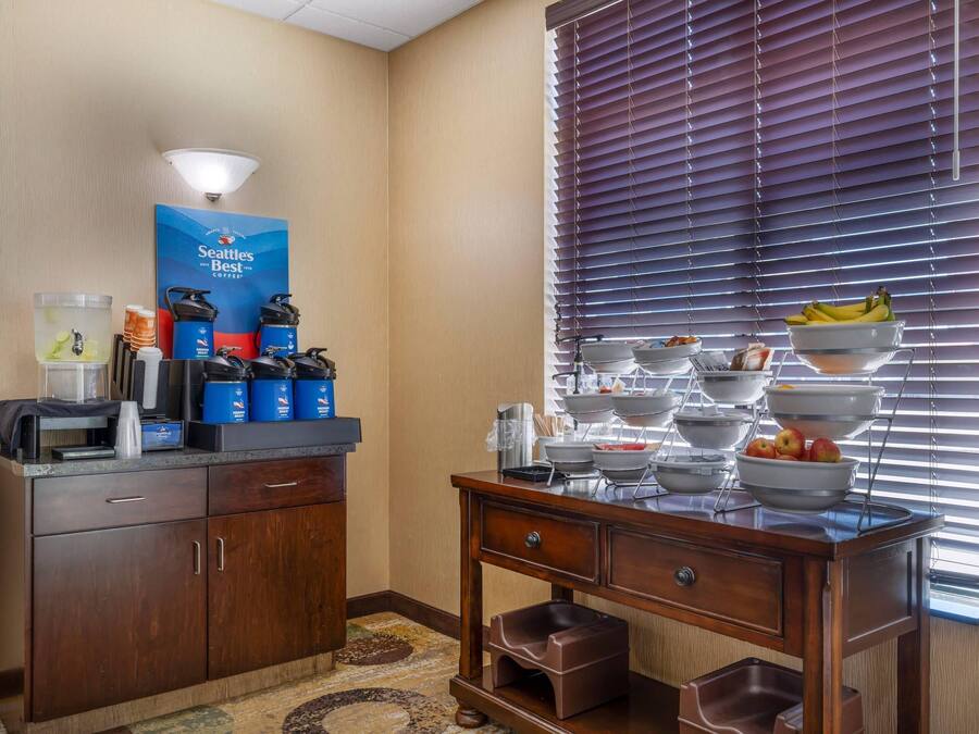 Habitación de hotel con estación de café, frutero y servicio tipo bufé.