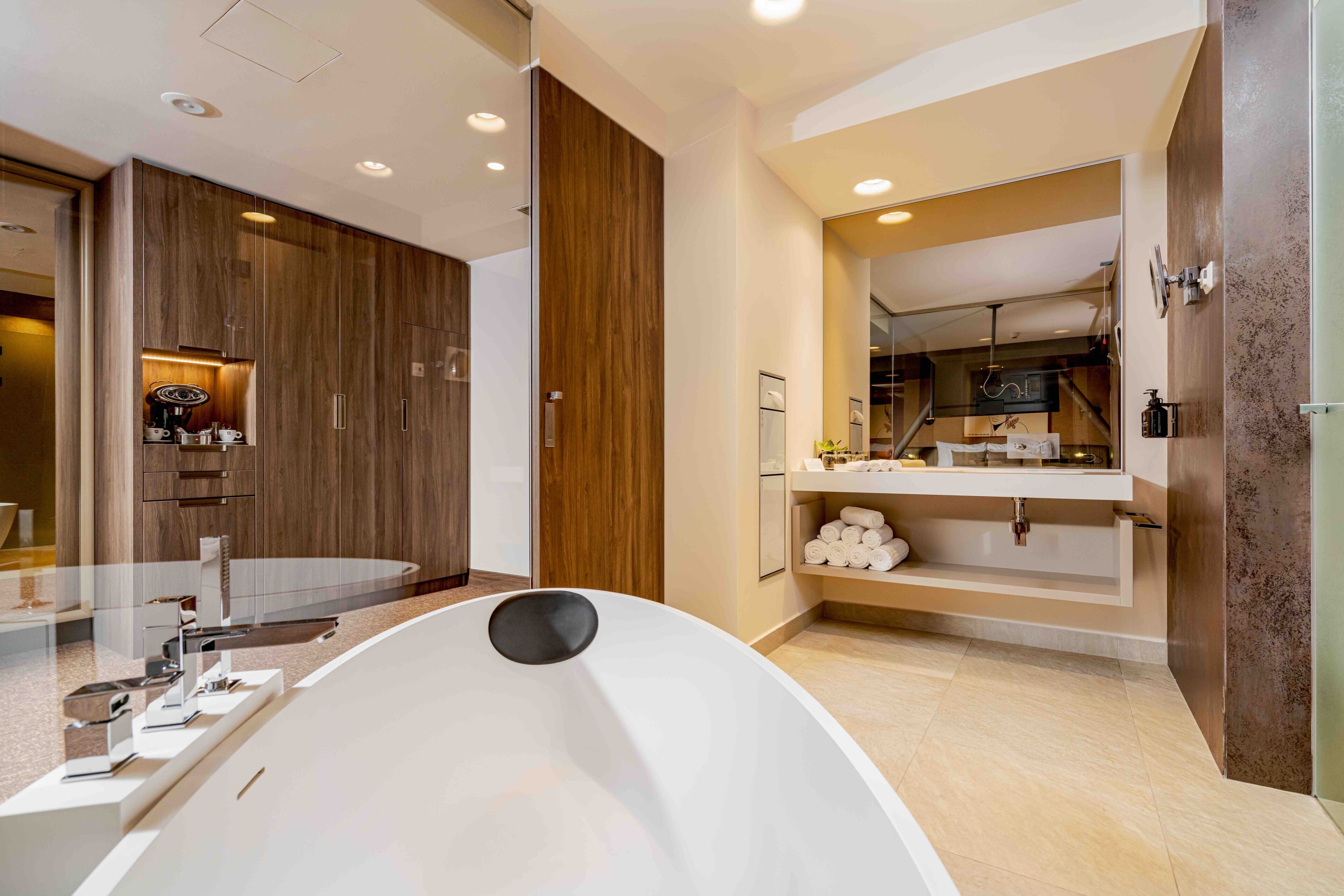 A modern bathroom with a freestanding bathtub, a vanity with a mirror, and a shower area.