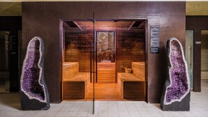 A sauna room with wooden benches and a central hot tub. - Kronwell Brasov Hotel (Brasov)