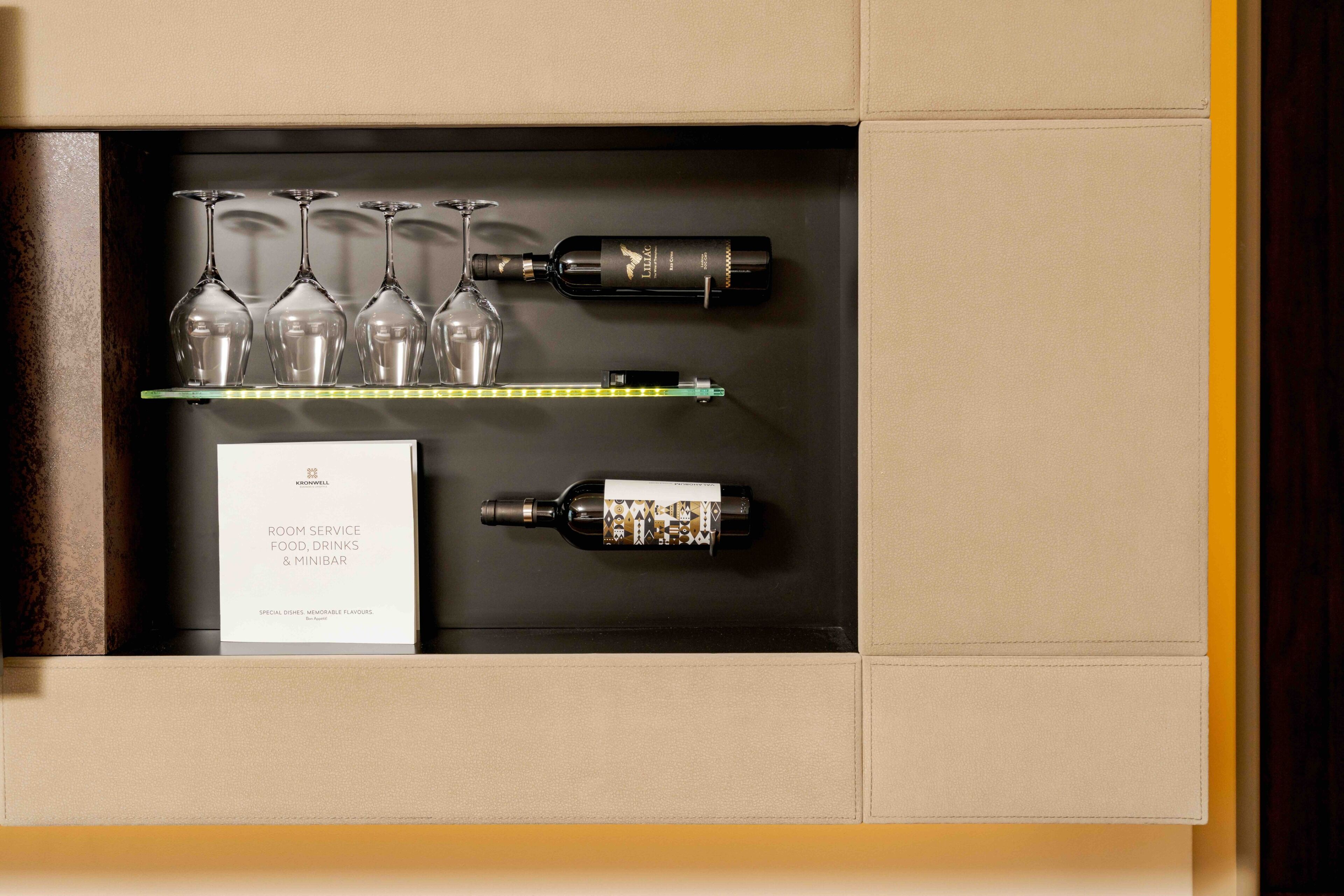 Un tiroir contenant des verres à vin, des bouteilles et un menu.