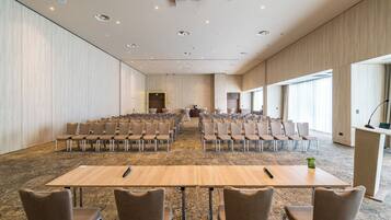A conference room with rows of chairs, a stage, and a podium.