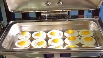A buffet setup with a tray of fried eggs.
