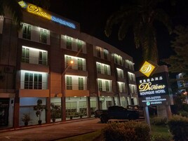 Un immeuble à plusieurs étages, doté d’une enseigne lumineuse pour le DeHome Boutique Hotel.