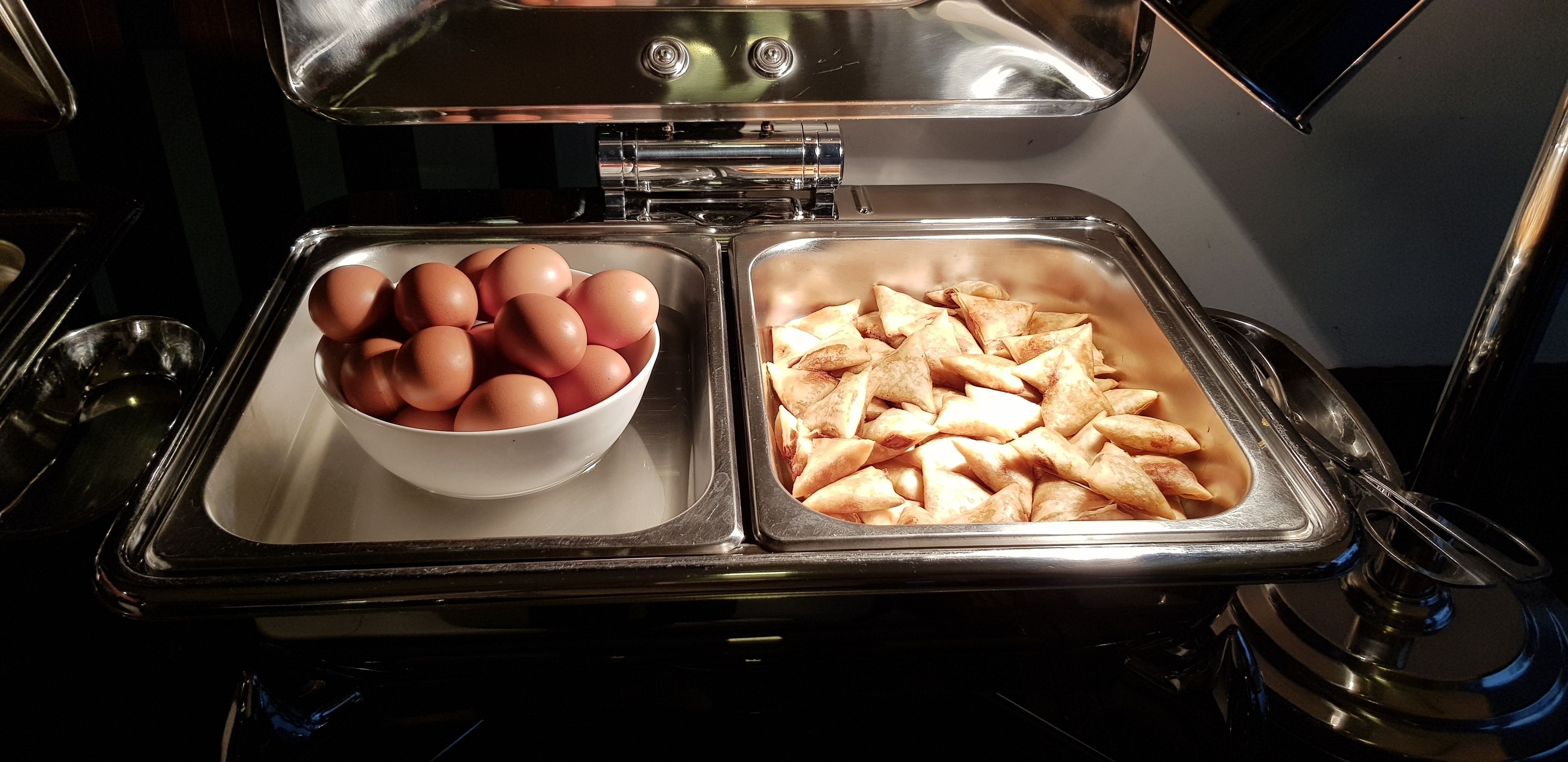 Un montaje tipo bufé con un bol de huevos y una bandeja de pasteles.