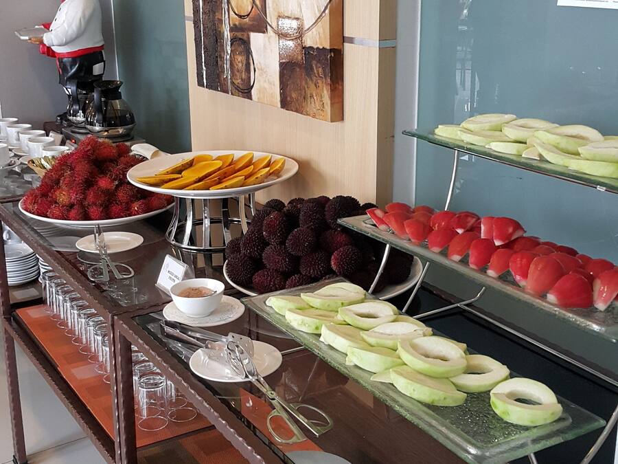 Un bufé con diversas frutas y una estatua de chef.