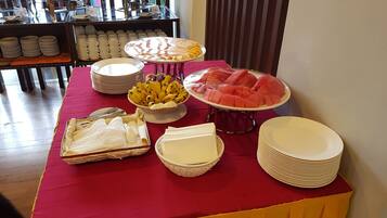 A buffet table with various food items and serving utensils.