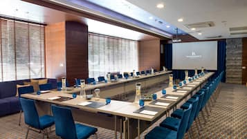 A conference room with a long table, blue chairs, and a screen displaying "Renaissance".
