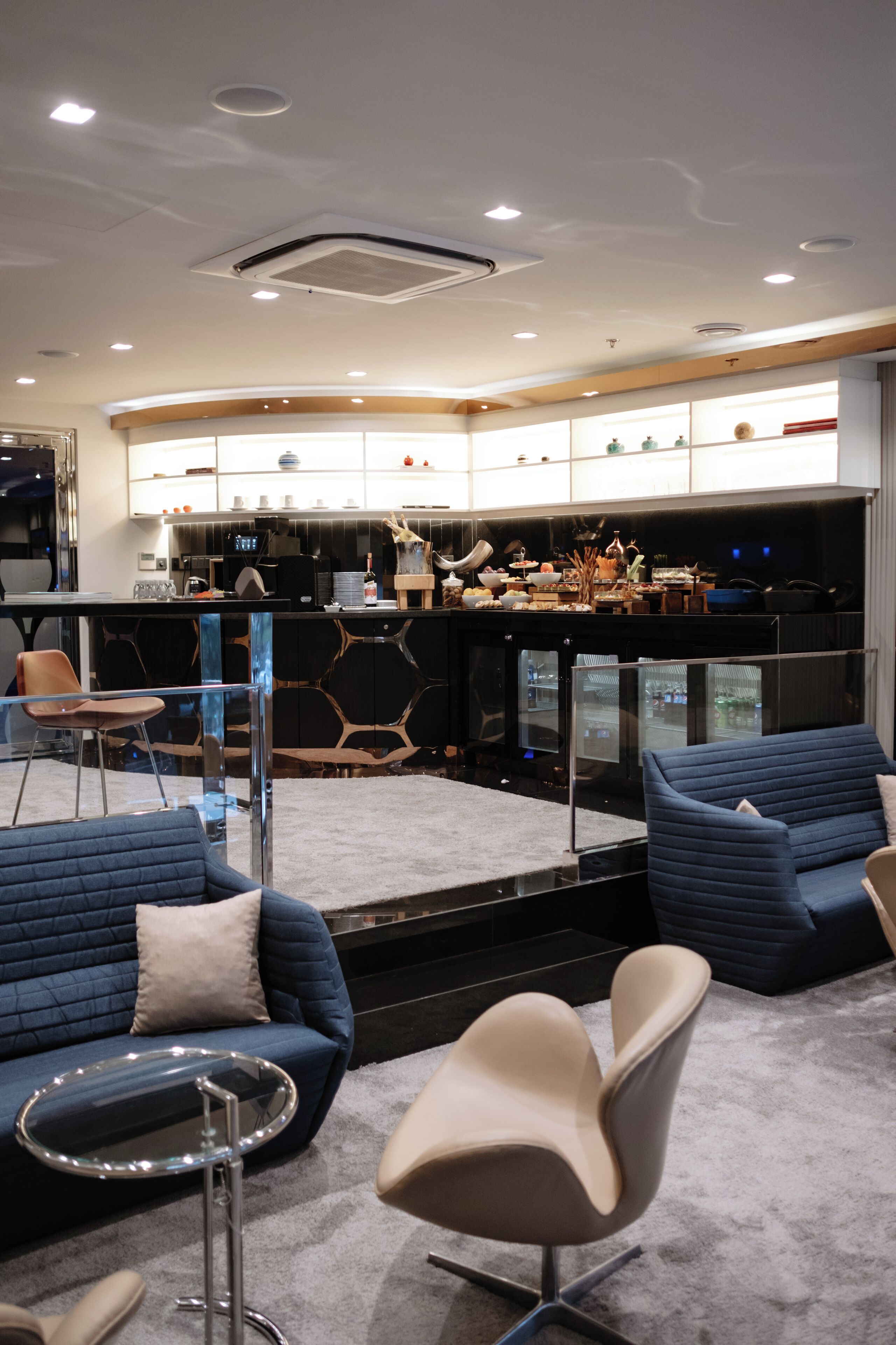A modern interior with a bar area, seating, and a kitchen.