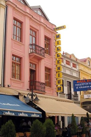 Un edificio rosa con un letrero que dice 'HOTEL MILLENIUM'.