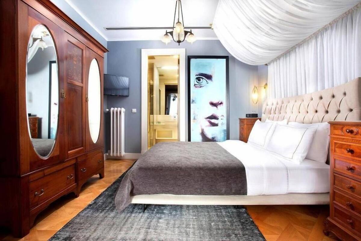Un dormitorio con cama, armario de madera y un espejo grande.