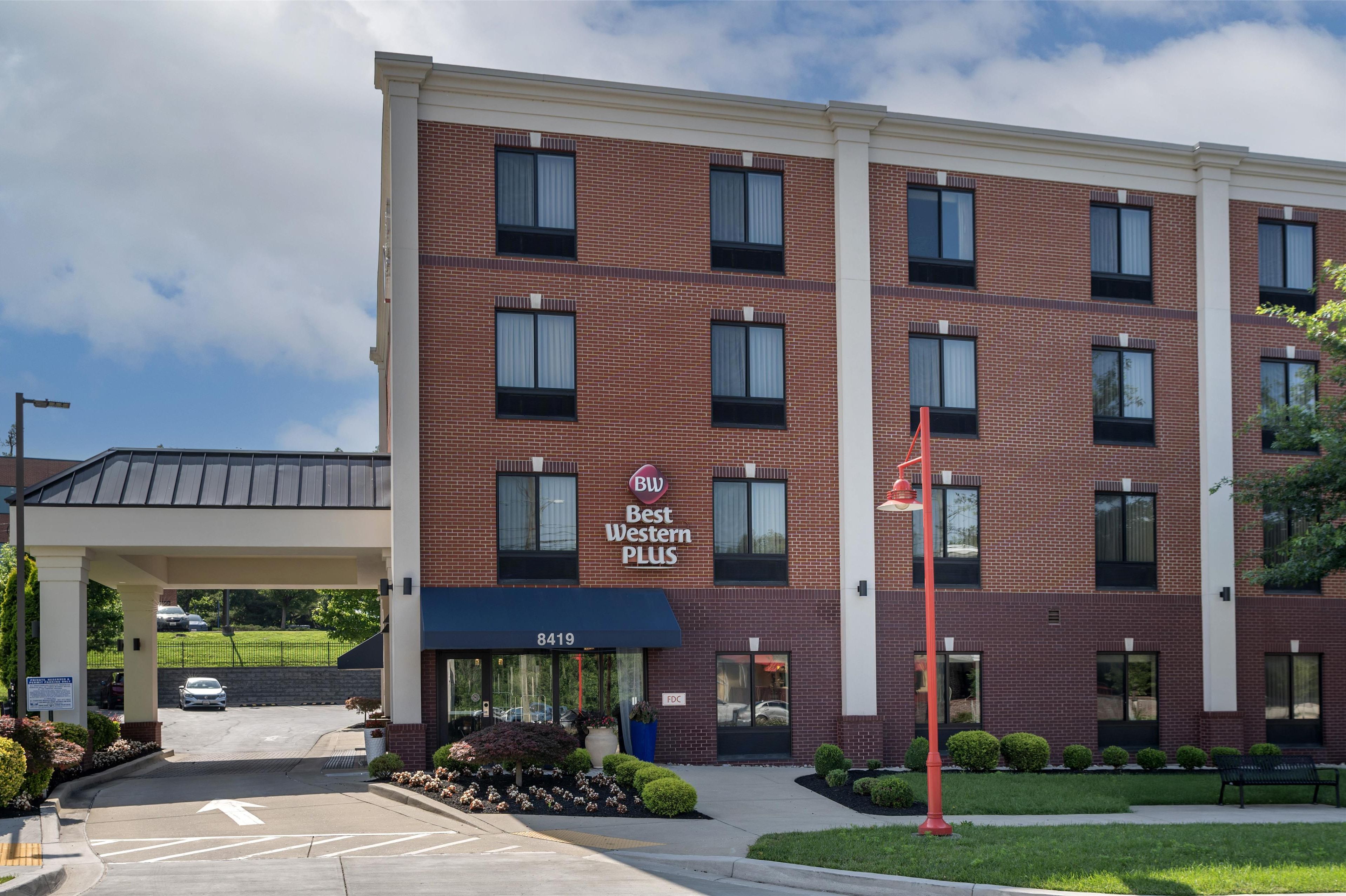 Un hôtel Best Western Plus avec une façade en briques, de nombreuses fenêtres et un parking.