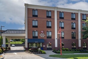 Een Best Western Plus hotel met een gevel van baksteen, veel ramen en een parkeerplaats.