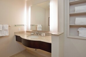 A bathroom with a sink, mirror, towel rack, and shelves with towels. - Residence Inn Odessa (Odessa)