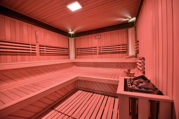 A sauna with wooden benches and a bench with a towel.